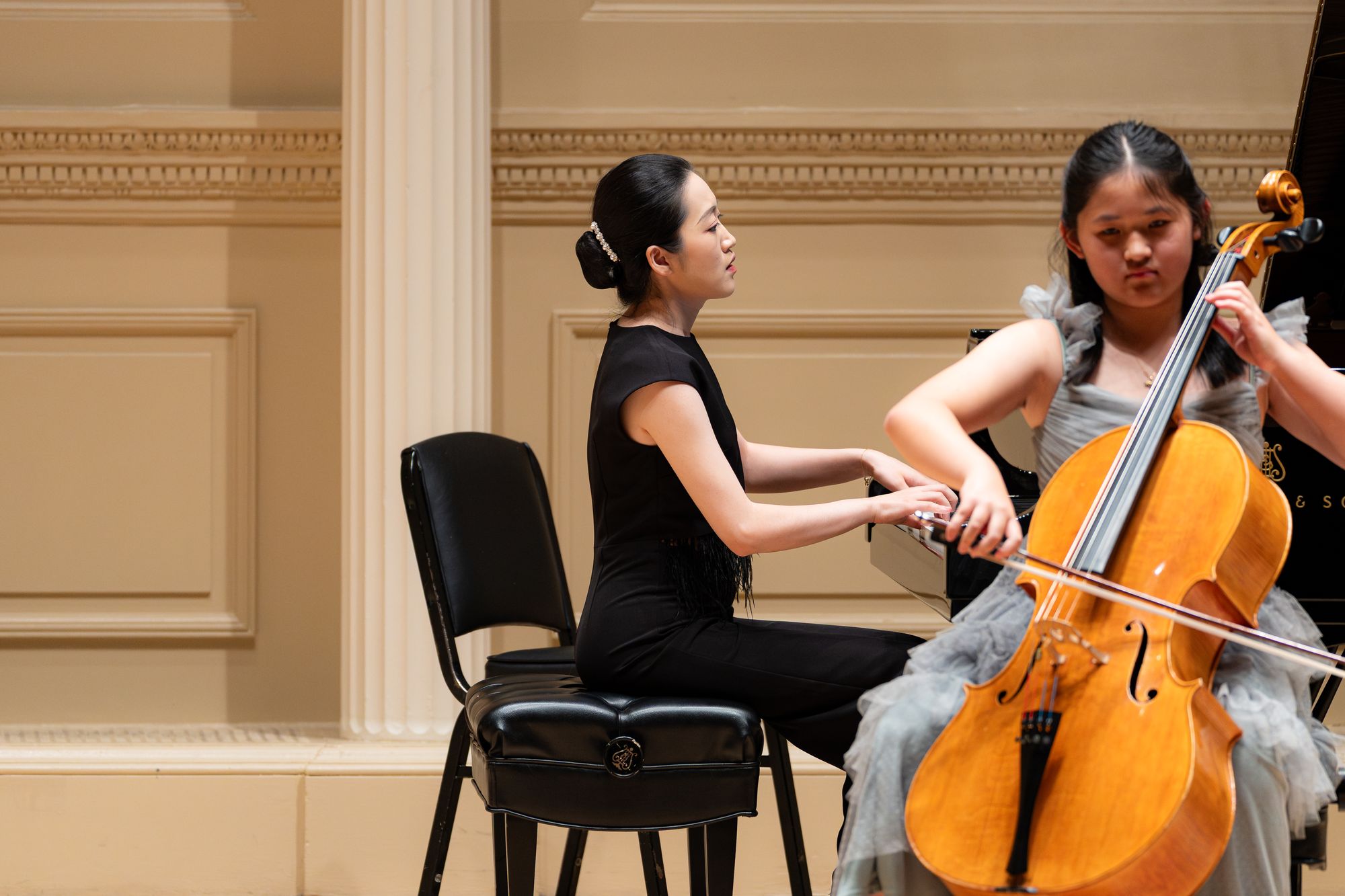 A young cellist performs with a pianist
